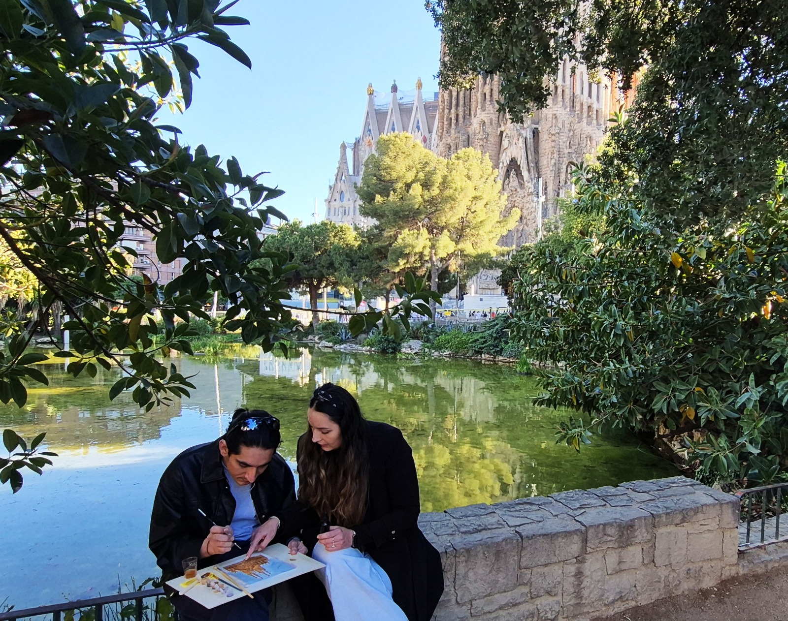 Pareja pintando junto al estanque de la Sagrada Família