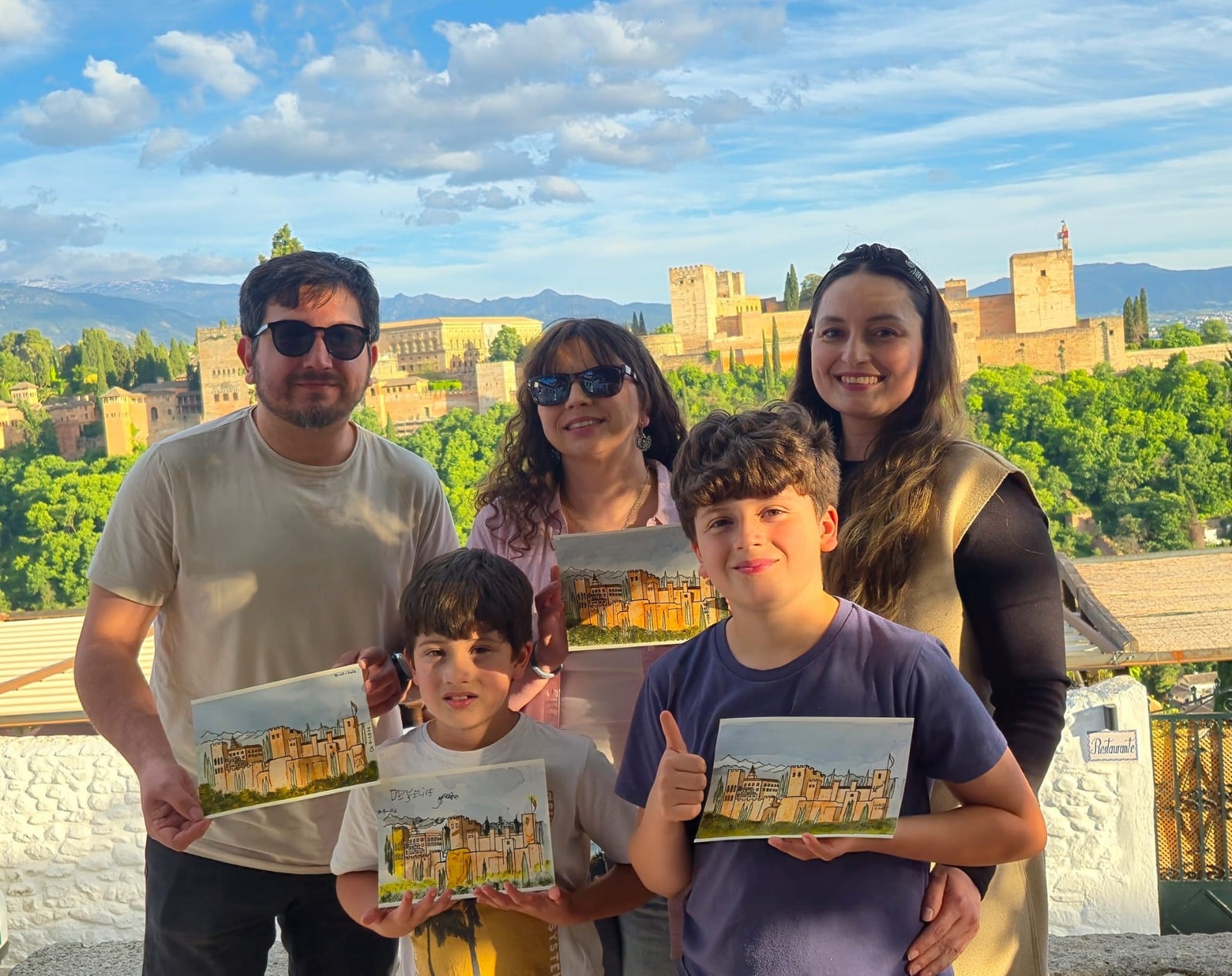 Familia mostrando sus postales pintadas